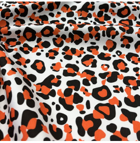 Tissu sergé de coton imprimé motif léopard orange et noir sur fond blanc